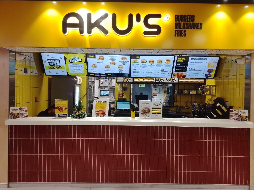 AKU’S fast food counter at Advant Navis Businesspark, Noida with yellow sign, menu boards, and burger options.
